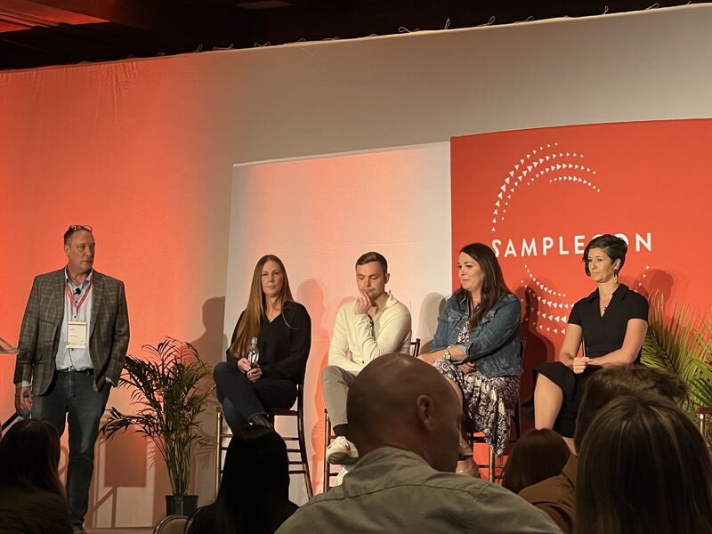 The SampleCon 2024 panel seated on stage in front of an orange SampleCon backdrop.