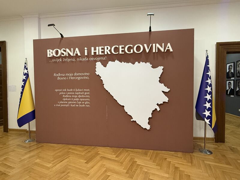 An exhibit wall reading "Bosna i Hercegovina" with a map outline, flanked by Bosnian flags.