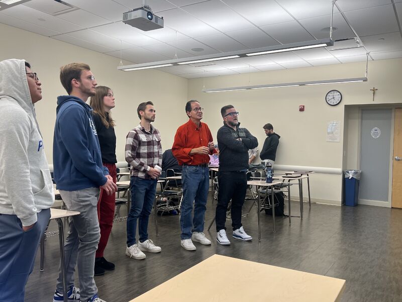 Students and guests standing at the front of a Seton Hall classroom.
