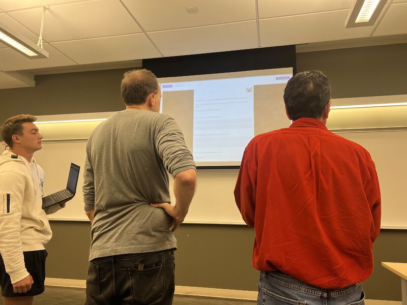 AJ Keirans and a student looking at a slide on the classroom screen.