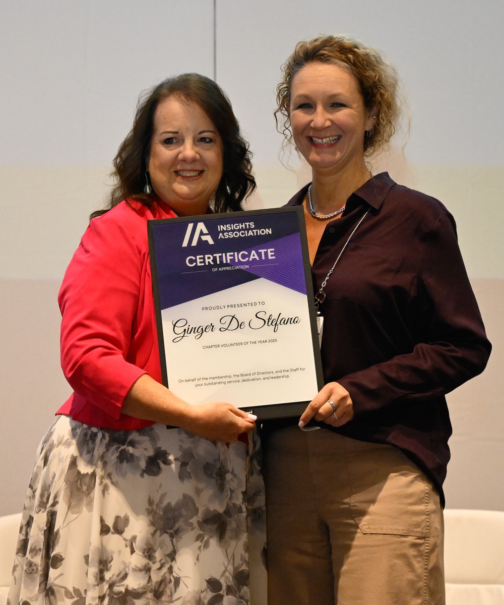 Ginger De Stefano on stage at CRC 2026 holding an Insights Association certificate.